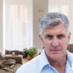 Man standing in a cozy Texas living room during bankruptcy, considering options to sell his house with Grandma House Buyer