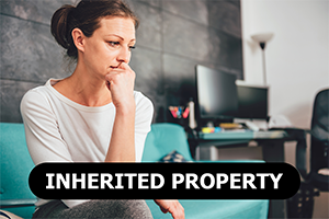 concerned woman sitting on couch thinking about selling her inherited property for cash in Bellaire